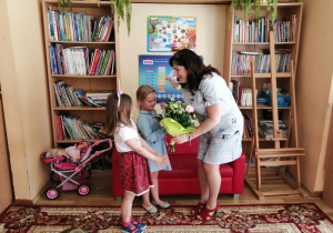 Wiktoria i Ada w imieniu wszystkich przedszkolaków wręczają kwiaty i laurkę, dziękując w ten sposób pani Elżbiecie za odwiedzenie naszego przedszkola i przybliżenie nam swojej twórczości.